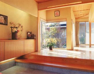 大理石を使ったひろびろとした玄関は老舗旅館のよう。窓の外には日本庭園が広がる。